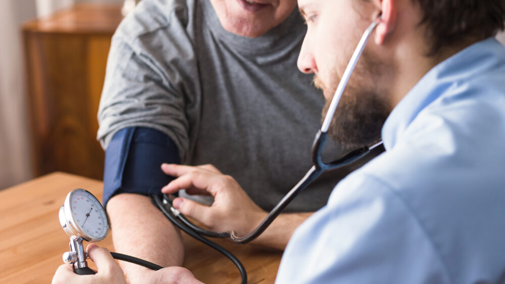 A doctor checking a patient's blood pressure using a sphygmomanometer.