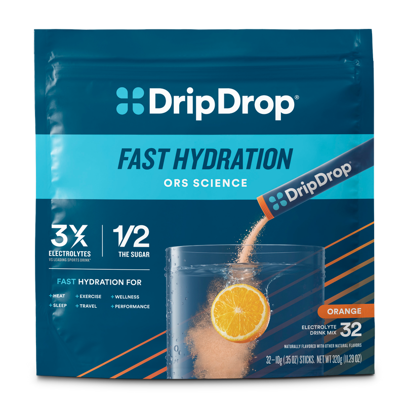 DripDrop Fast Hydration drink mix in an orange flavor pouch. The packaging is dark blue with bright blue and orange accents, featuring a graphic of an orange slice in a glass of water with powder dissolving.