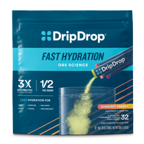 A package of DripDrop Fast Hydration electrolyte drink mix in the Sunburst Variety. The pouch is dark blue with a cyan band and features an illustration of yellow powder being poured into a clear cup, with text highlighting key benefits like '3X Electrolytes' and '1/2 the Sugar'.