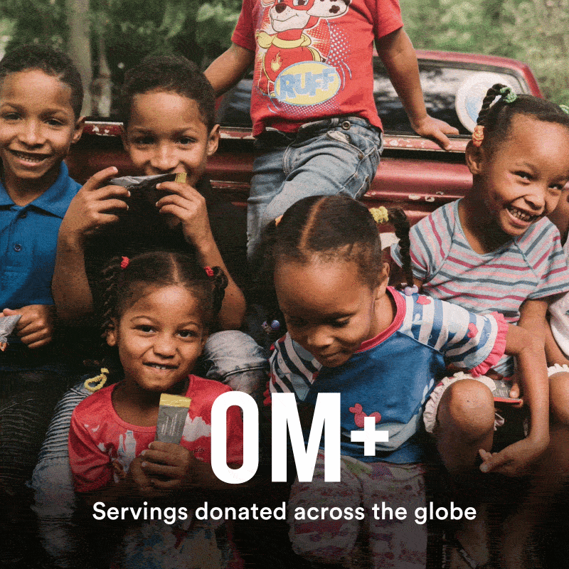 An image of children sitting on the back of a truck with 13M+ Servings donated across the globe