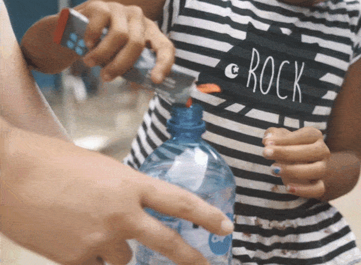 A video of kids putting DripDrop in a water bottle and mixing it up to drink