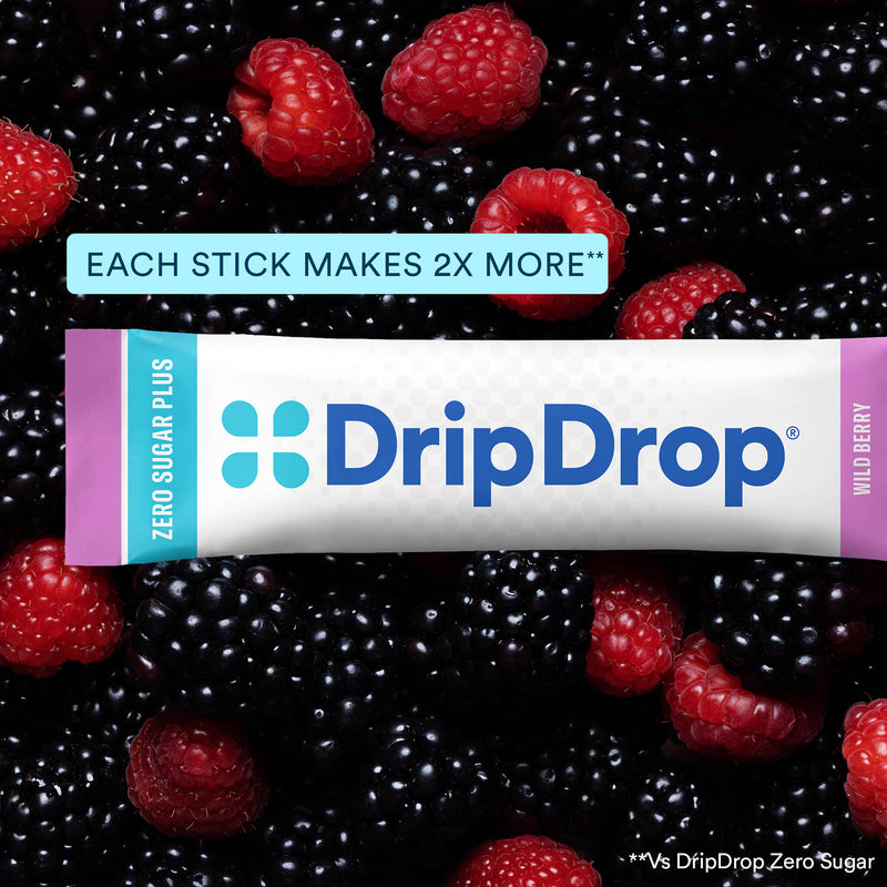 A DripDrop Zero Sugar Plus wild berry stick product shown wrapped in its white, blue, and pink packaging, placed over a close-up background of fresh blackberries and raspberries. A text banner at the top reads 'EACH STICK MAKES 2X MORE'.