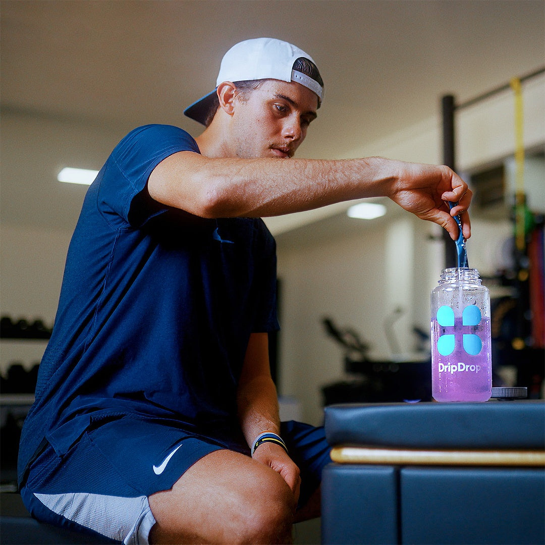 Jack Hughes in a gym pouring a stick of DripDrop into a bottle
