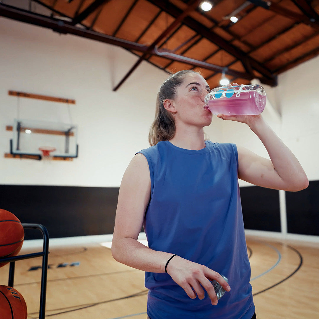 Kate Martin on a basketball court drinking DripDrop